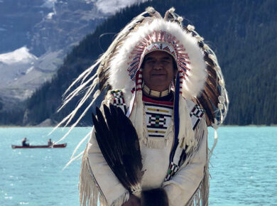 Indigenous native chief standing by the lake Louise in Canada
